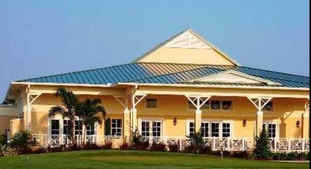 1370 Bunker Ct, Vero Beach, FL 32966 - back of property featuring a yard, a metal roof, and stucco siding