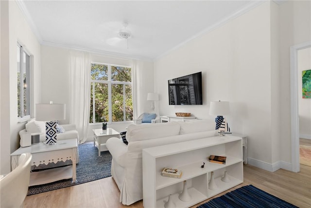 living area with light wood-type flooring, baseboards, and ornamental molding