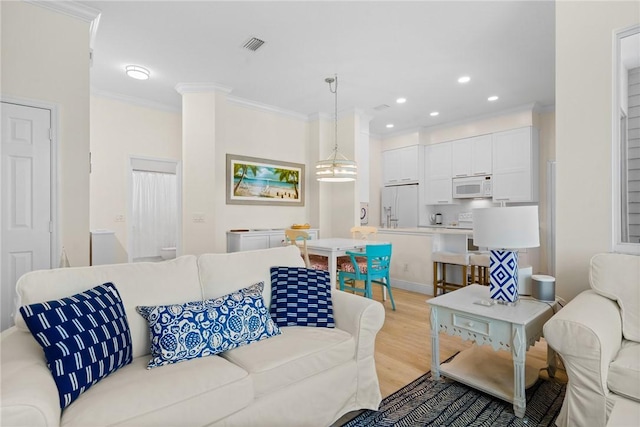 living area featuring light wood finished floors, visible vents, recessed lighting, and crown molding