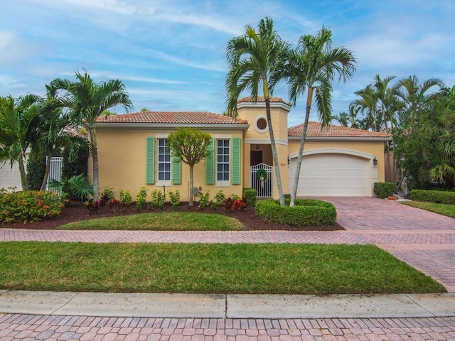 mediterranean / spanish-style house featuring a garage and a front yard