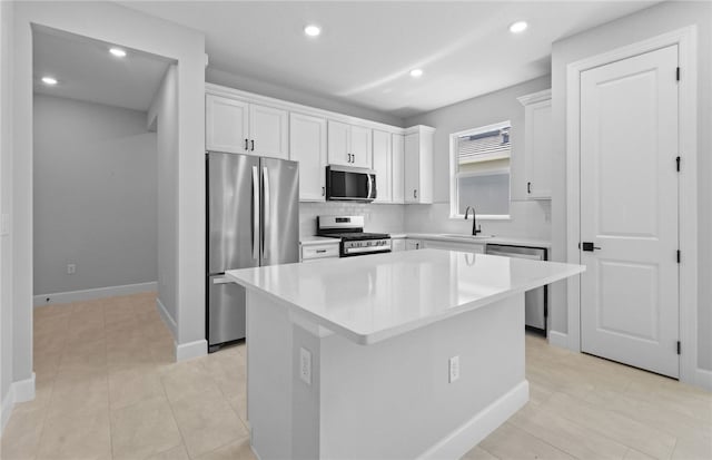 1279 Harper Way Unit 013, Vero Beach, FL 32960 - kitchen with stainless steel appliances, a sink, tasteful backsplash, a kitchen island, and white cabinets