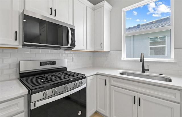 1279 Harper Way Unit 013, Vero Beach, FL 32960 - kitchen featuring appliances with stainless steel finishes, a sink, white cabinetry, and backsplash