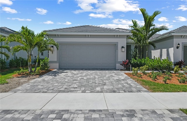 1279 Harper Way Unit 013, Vero Beach, FL 32960 - view of front facade with decorative driveway, stucco siding, a garage, and a tile roof