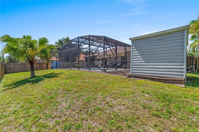 view of yard featuring glass enclosure, a fenced backyard, and a fenced in pool