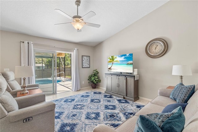 living room featuring baseboards, ceiling fan, a textured ceiling, and lofted ceiling