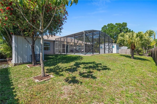 view of yard with an outbuilding, glass enclosure, a storage unit, and a fenced backyard