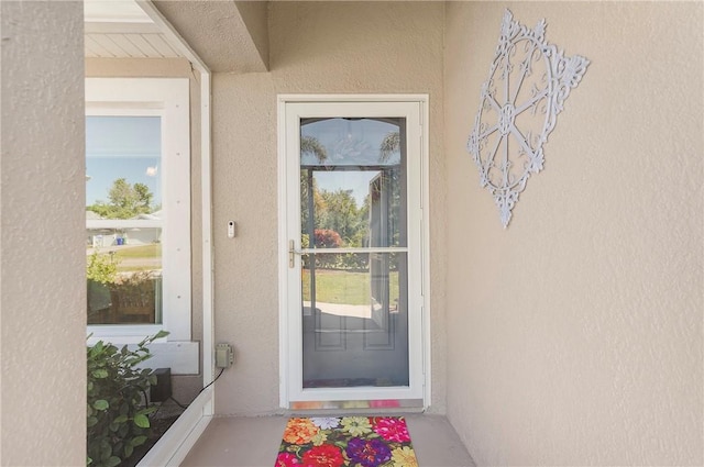 property entrance with stucco siding