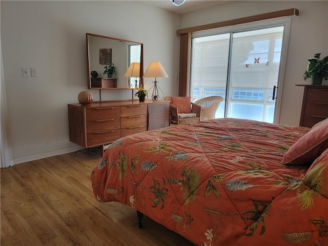 28 Pine Arbor Ln Unit 202, Vero Beach, FL 32962 - bedroom with light wood-type flooring, access to outside, and baseboards