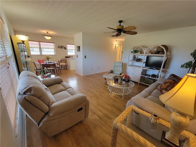 28 Pine Arbor Ln Unit 202, Vero Beach, FL 32962 - living area featuring a textured ceiling, ceiling fan, wood finished floors, and baseboards
