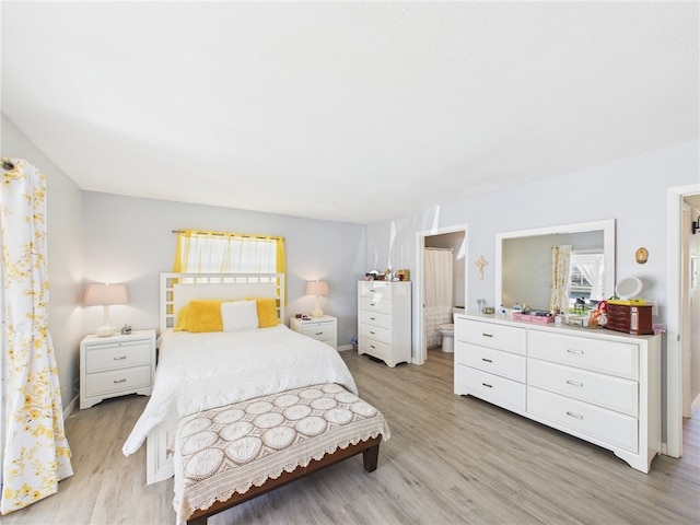 96 Spring Lake Dr Unit 105, Vero Beach, FL 32962 - bedroom with light wood-style flooring and connected bathroom