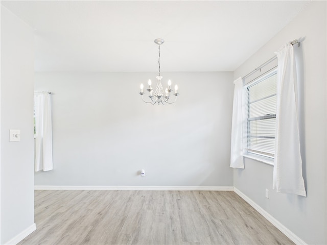 96 Spring Lake Dr Unit 105, Vero Beach, FL 32962 - spare room with wood finished floors and a chandelier