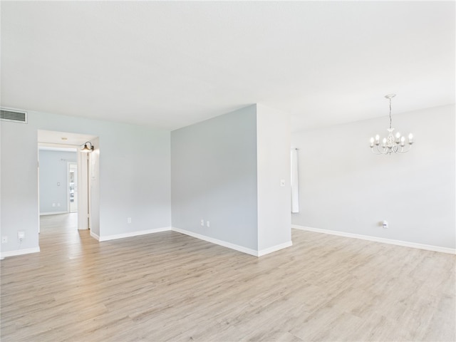 96 Spring Lake Dr Unit 105, Vero Beach, FL 32962 - unfurnished room with a chandelier and light wood finished floors