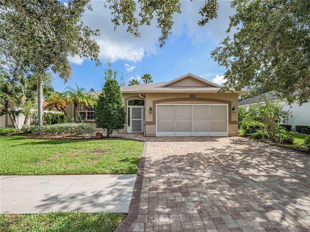 single story home with a garage and a front lawn