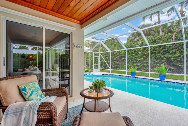 outdoor pool featuring glass enclosure and a patio area