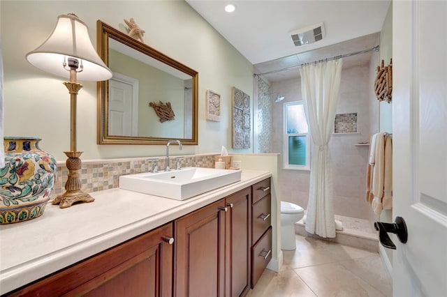 bathroom featuring tasteful backsplash, visible vents, toilet, vanity, and a shower stall