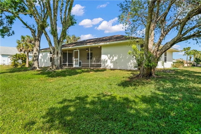 rear view of property featuring a sunroom and a yard