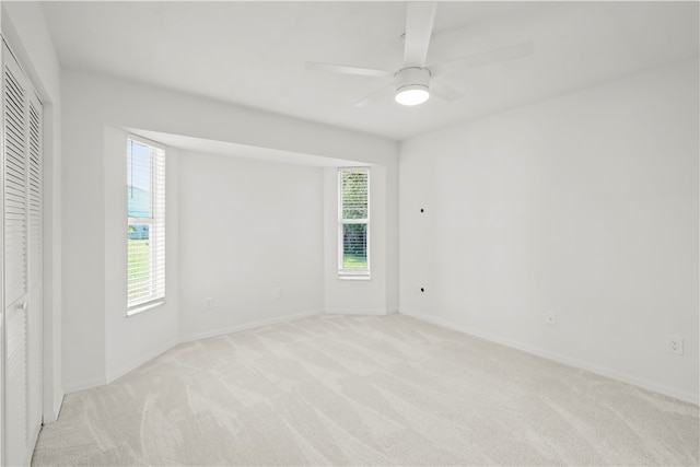 unfurnished room featuring light colored carpet and ceiling fan