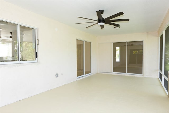 unfurnished sunroom featuring ceiling fan