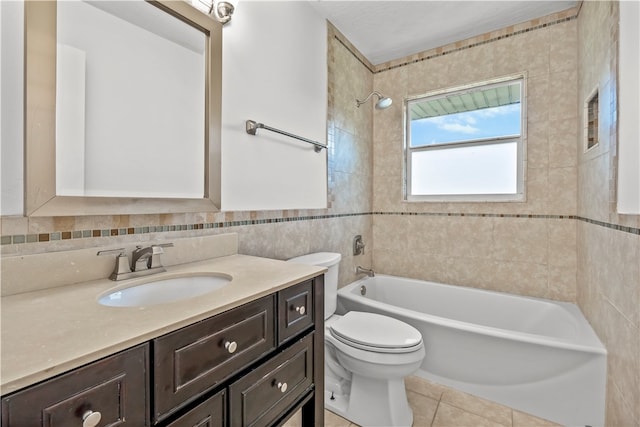 full bathroom with tile walls, vanity, tile patterned flooring, toilet, and tiled shower / bath