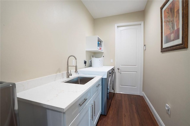 laundry room featuring cabinet space, washing machine and clothes dryer, dark wood-type flooring, and baseboards