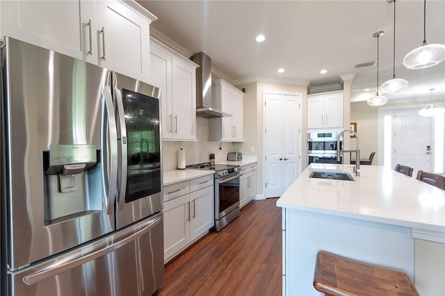 kitchen featuring stainless steel appliances, wall chimney range hood, dark wood-type flooring, ornamental molding, and light countertops