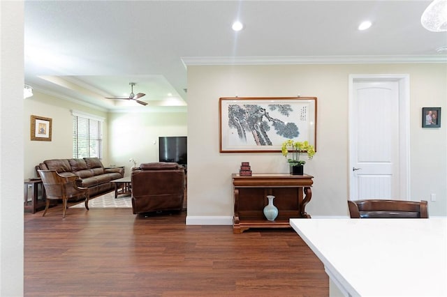 living area featuring crown molding, dark wood-type flooring, a ceiling fan, recessed lighting, and baseboards