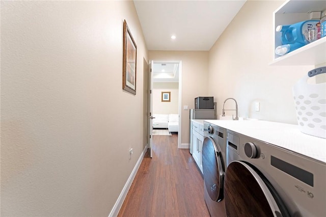 laundry area featuring separate washer and dryer, cabinet space, dark wood-style floors, baseboards, and recessed lighting