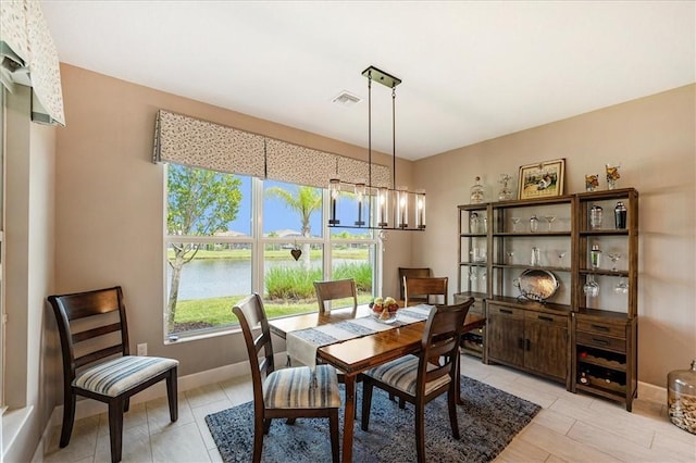 11706 SW Brighton Falls Dr, Port St Lucie, FL 34987 - dining room featuring a chandelier and a water view