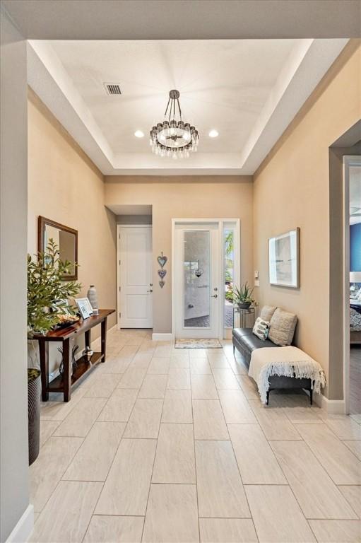 11706 SW Brighton Falls Dr, Port St Lucie, FL 34987 - entrance foyer with a chandelier, a tray ceiling, and recessed lighting