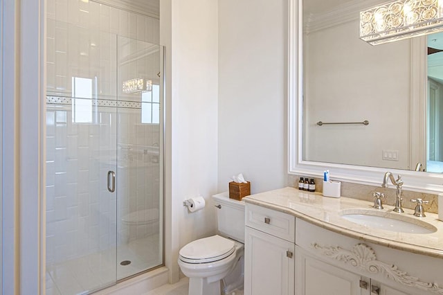 bathroom with vanity, crown molding, a shower with shower door, and toilet