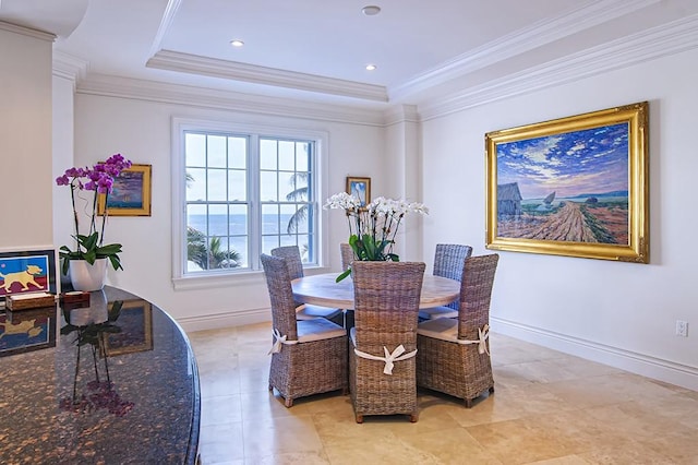 dining space with ornamental molding and a tray ceiling