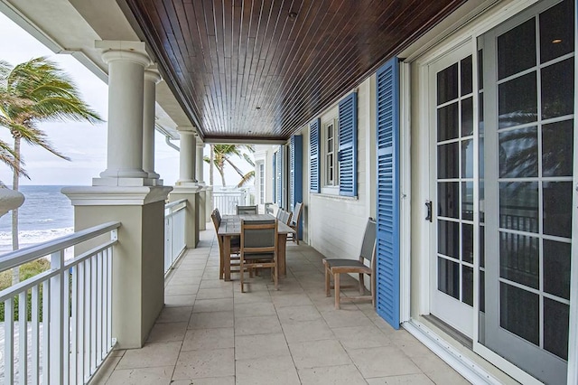 balcony featuring covered porch and a water view