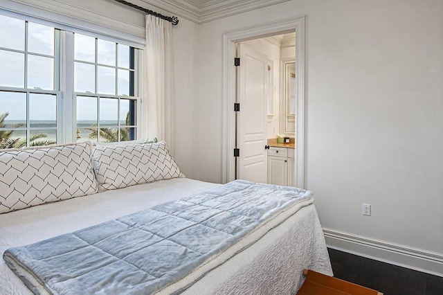 bedroom with ensuite bath, multiple windows, crown molding, and a water view