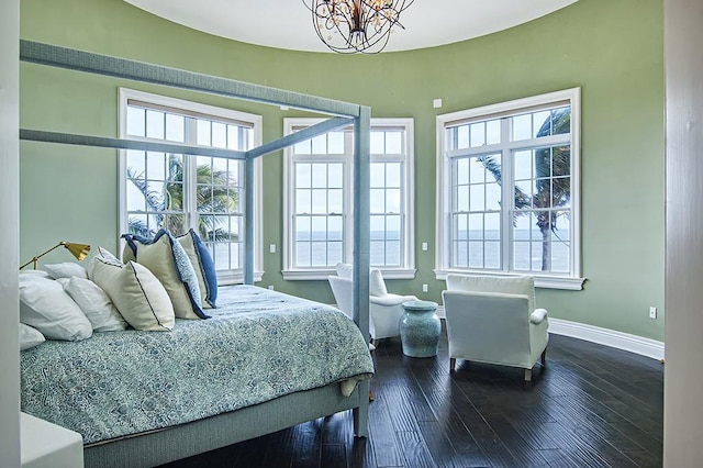 bedroom with a notable chandelier, wood-type flooring, and multiple windows