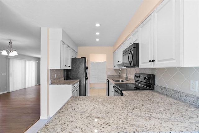 640 N Centre Ct SW Unit 102, Vero Beach, FL 32962 - kitchen with black appliances, white cabinets, light stone countertops, tasteful backsplash, and recessed lighting
