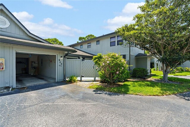 640 N Centre Ct SW Unit 102, Vero Beach, FL 32962 - view of property exterior featuring asphalt driveway, a garage, and board and batten siding