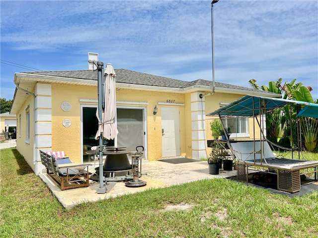 rear view of house featuring a patio area and a lawn