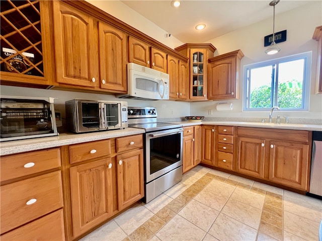 kitchen featuring pendant lighting, stainless steel electric range oven, sink, and light tile patterned floors