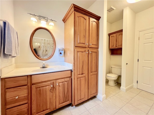 bathroom with vanity, tile patterned floors, and toilet