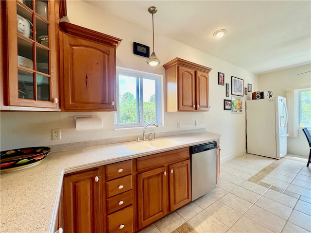 kitchen featuring sink, light tile patterned floors, hanging light fixtures, white fridge, and dishwasher