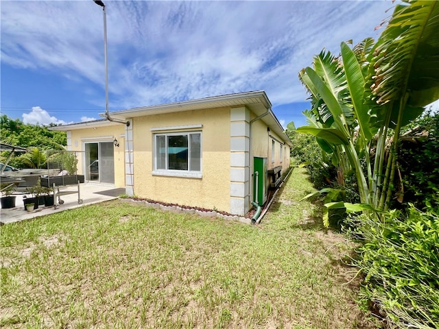 rear view of property featuring a yard and a patio area