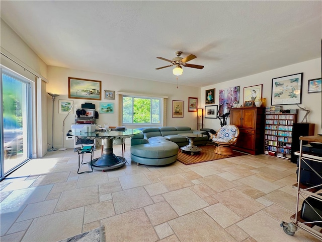 living room with a textured ceiling and ceiling fan