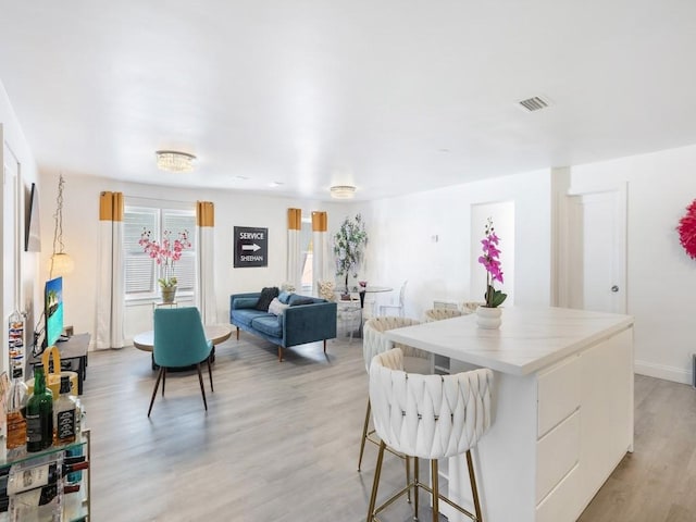 kitchen with a kitchen breakfast bar, a center island, and light hardwood / wood-style flooring