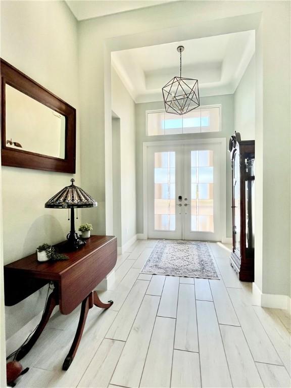 entryway with a raised ceiling and french doors