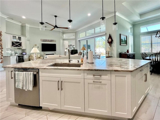 kitchen featuring white cabinetry, sink, stainless steel dishwasher, and hanging light fixtures