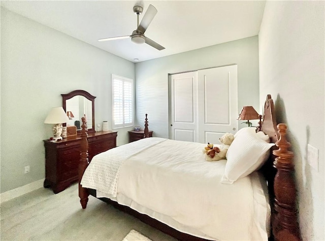 bedroom with ceiling fan, light colored carpet, and a closet