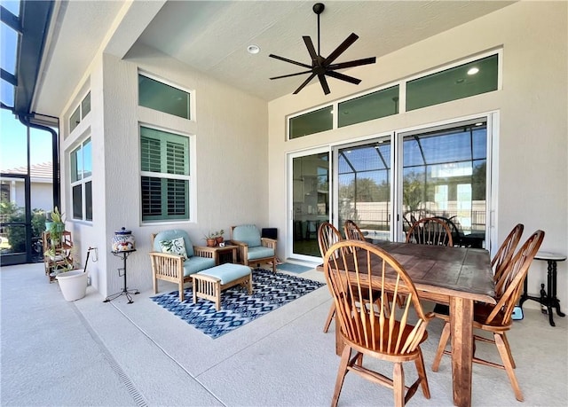 view of patio featuring ceiling fan and glass enclosure