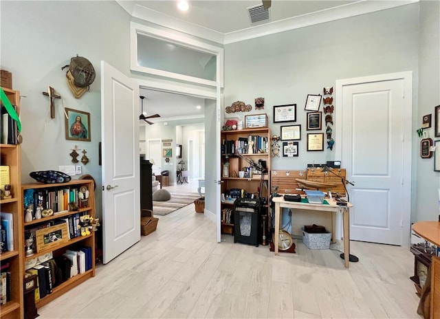 interior space with crown molding, ceiling fan, and light hardwood / wood-style flooring