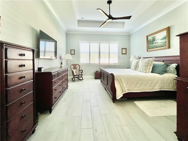 bedroom featuring light hardwood / wood-style flooring, ornamental molding, a raised ceiling, and ceiling fan