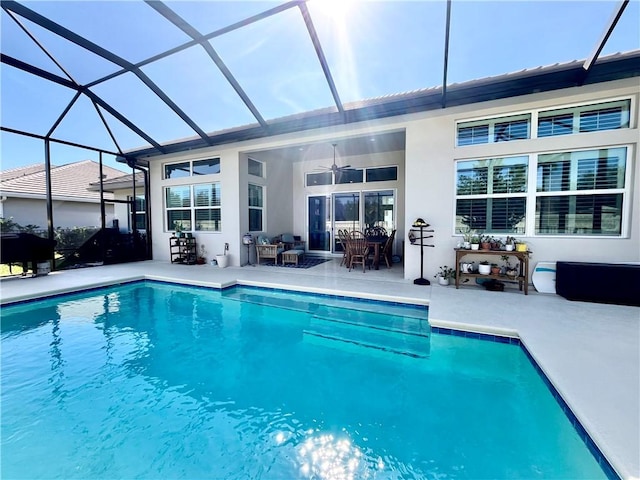 view of pool with a patio area, ceiling fan, and glass enclosure